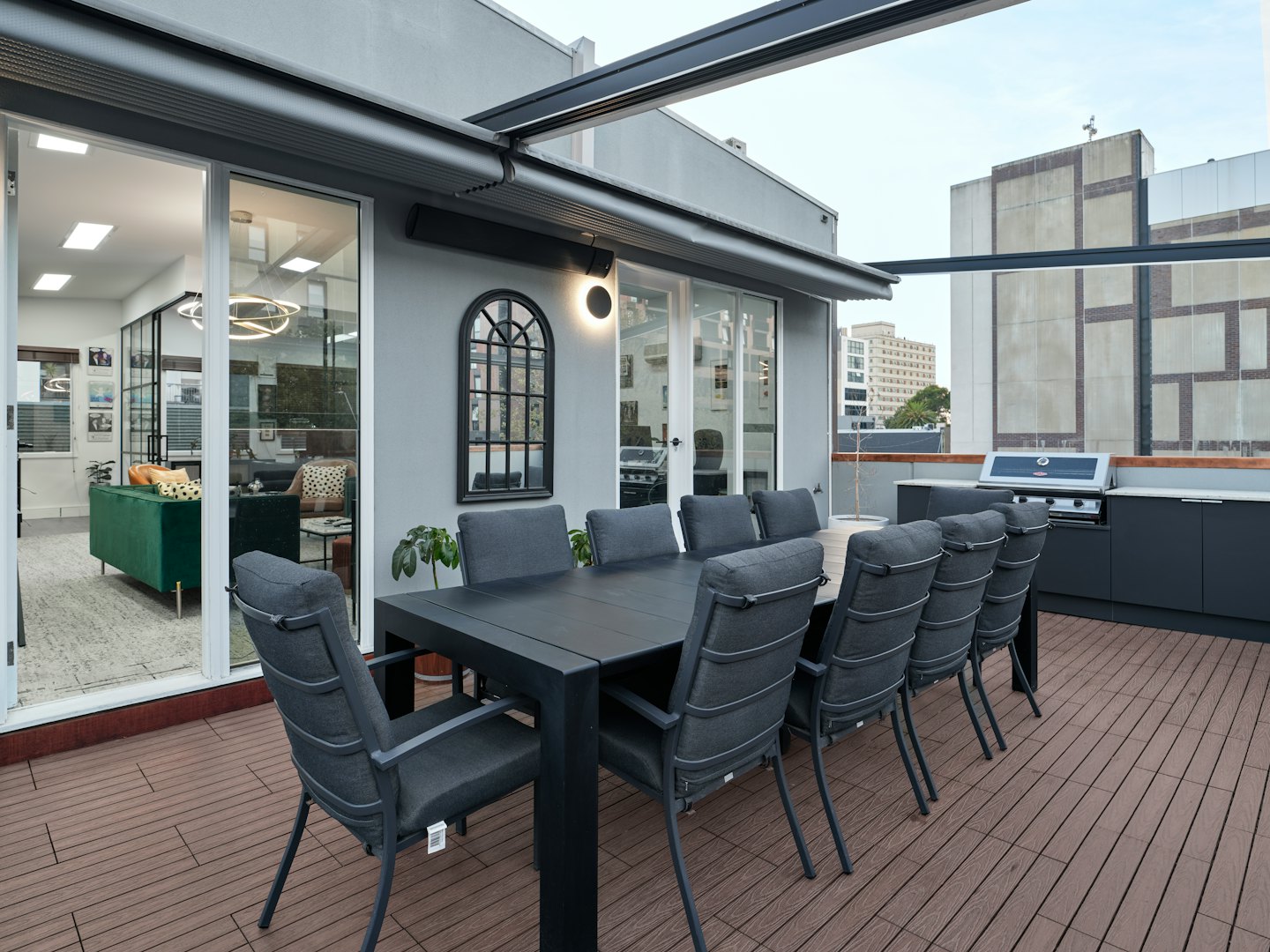 Moderne Dachterrasse mit Essmöbeln und Außenküche.