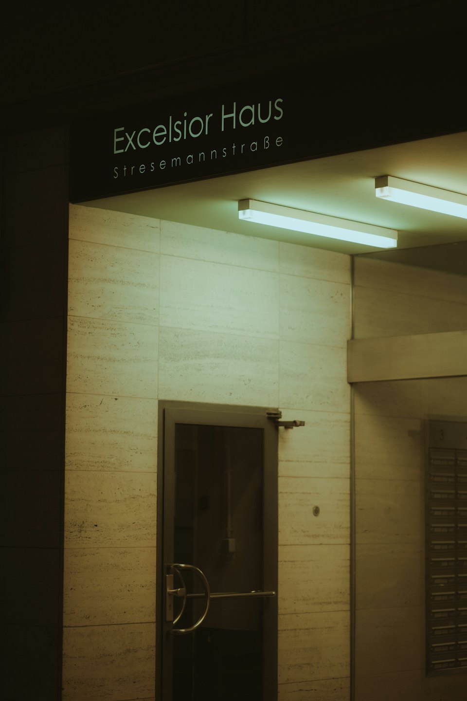 Gläserne Eingangstür des Excelsior Haus Gebäudes.